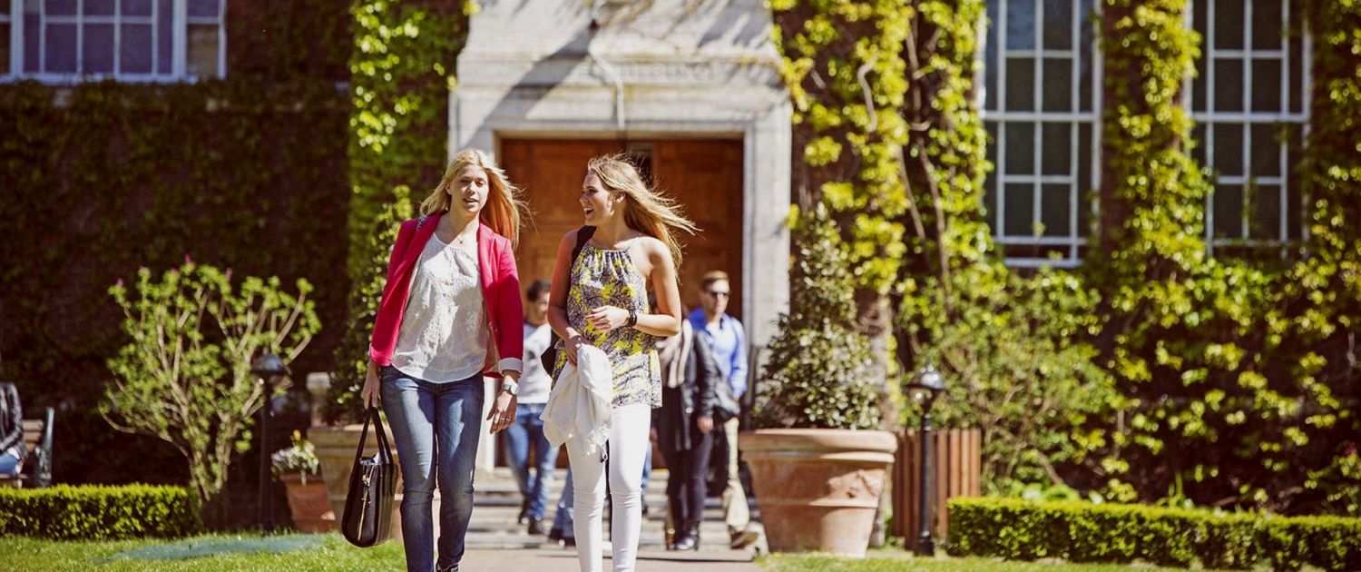 Study Students walking in front of the University entrance